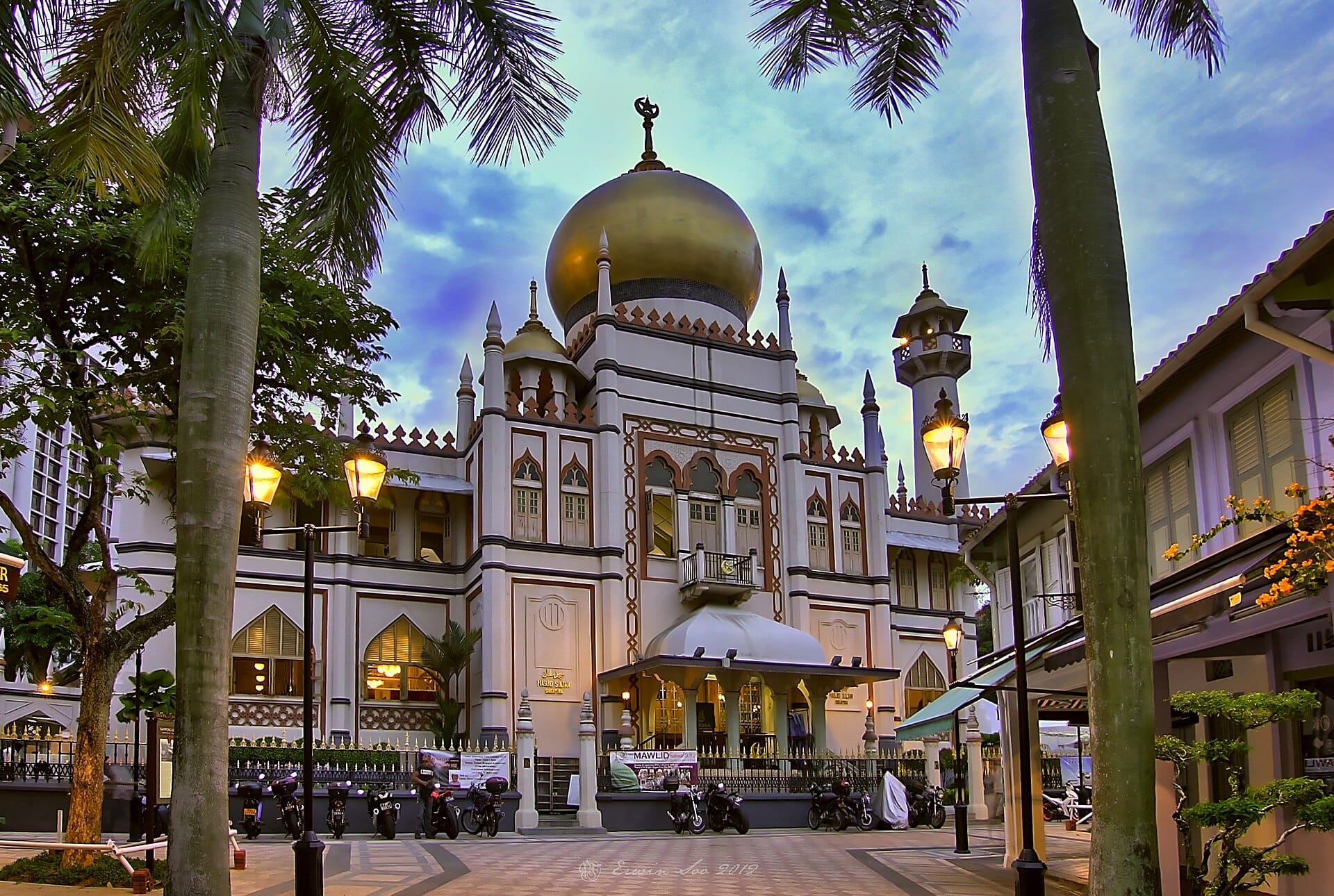 Golden-domed mosque surrounded by palm trees and lit street lamps, text reading "Kampong Glam" and "Start Your Journey."